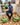Ghanaian artisan weaver sitting on a chair with colorful woven pet baskets in a home setting