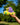 Hand holding a yellow and purple snail-shaped plush toy with a blurred green and blue background