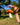 Hand holding a toy mushroom against a blurred outdoor background