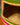 Close-up of a woven pet basket with colourful edges on a wooden surface.