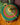 Colourful woven pet basket / cat cave with colourful handle on a wooden floor.